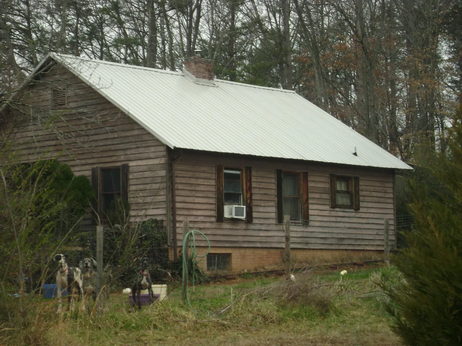 White metal roof on an old wood sided farmhouse, from a Metal Roof Installation job in Batesville